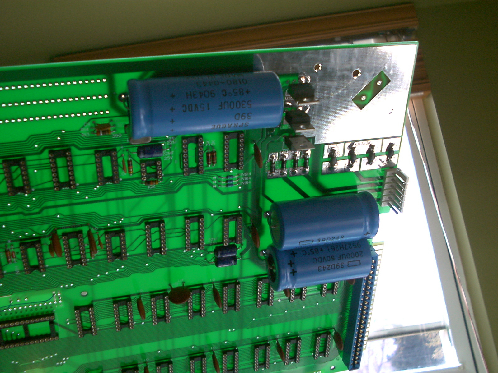 PCB held upside down - capacitor leads not yet soldered